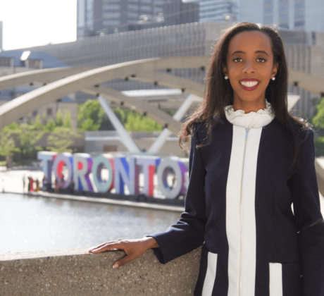 A Picture of Saron Gebresellassi standing in front of the Toronto sign, in front of City Hall