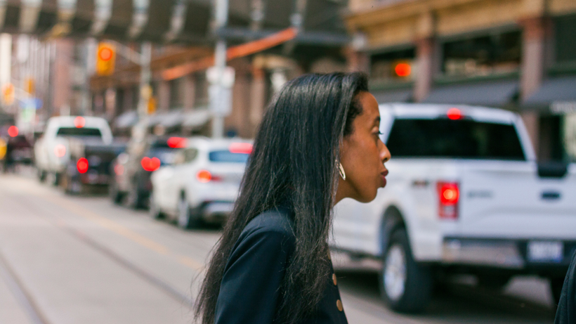 Saron Gebresellassi is running for Mayor in the 2018 Toronto municipal election and in the photo is seen crossing a street in Toronto, with cars blurred in background image.
